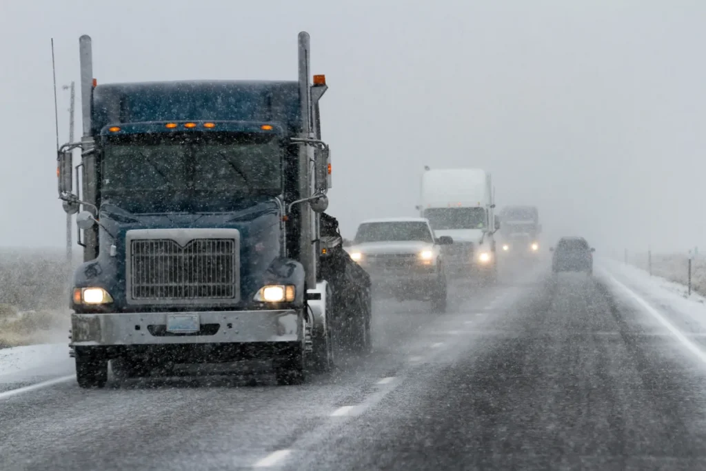 A picture of semi trucks on a foggy one-way highway road