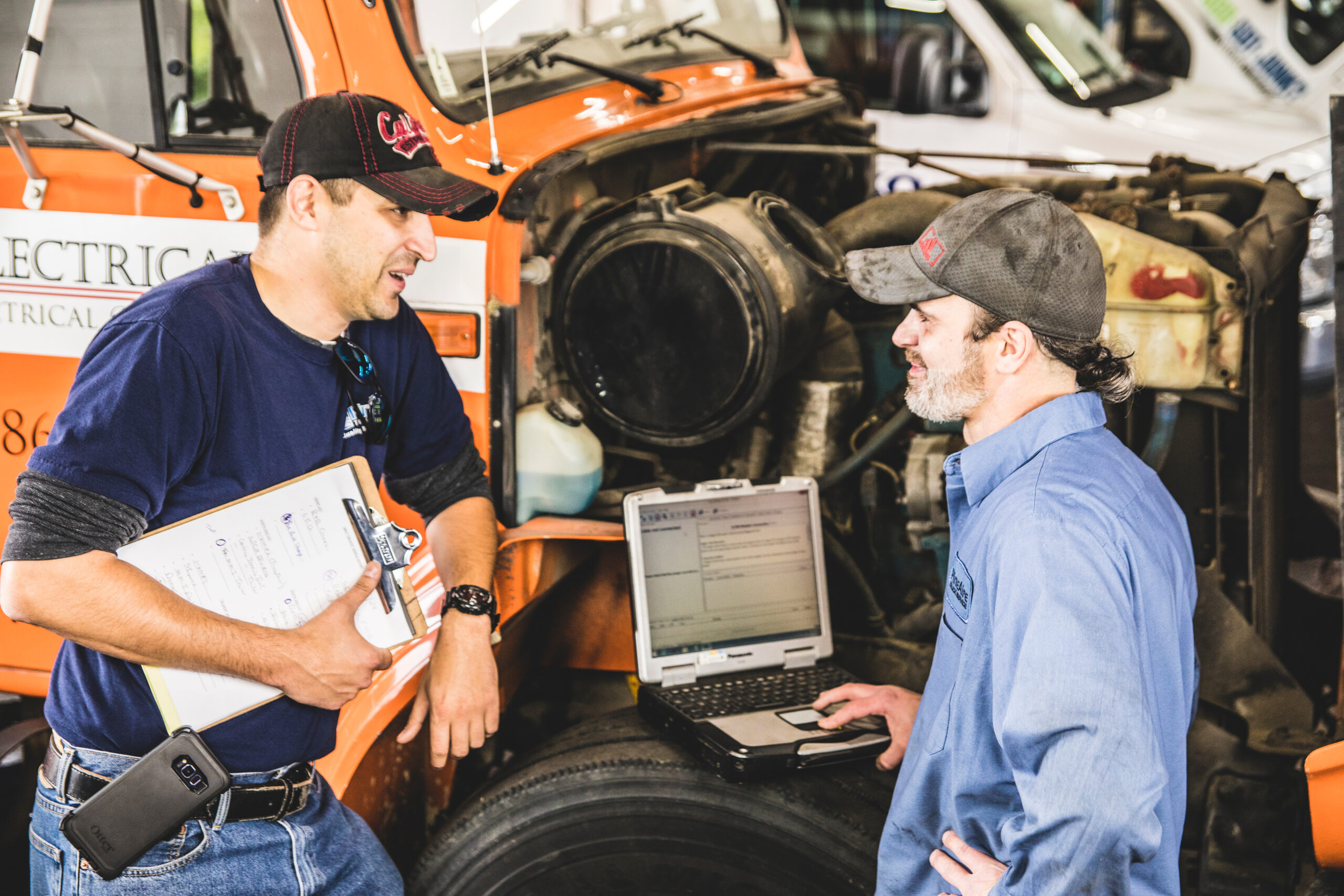 Two repair truck DOT inspection specialists talking together